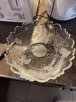 Top view of clear glass bowl showing etched fruit and scalloped rim