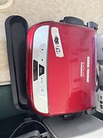 Closed red George Foreman Evolve grill with drip tray
