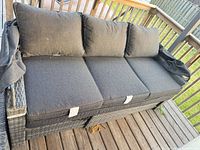 Gray wicker 3-seat sofa with cushions and collapsed canopy