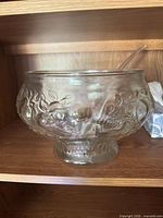 Front view of footed glass punch bowl showing embossed fruit pattern
