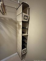 Beige fabric six-shelf hanging organizer suspended from wire closet rod