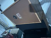 Speaker cabinet showing wood veneer and black grille