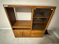 Front view showing open shelf, glass-door cabinet, drawers