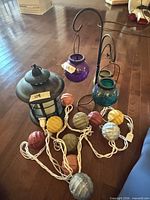 Group shot showing lantern, string lights, metal stand with two glass tealight holders