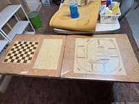 Full table showing three printed game boards on laminate top and folding legs