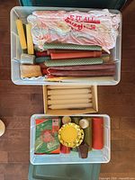 Overall view of two bins showing rolled beeswax tapers, boxed candles, tealights, pillar