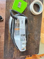 Top view of Proctor-Silex iron with cord wrapped around handle and identification label visible