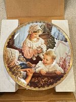 Front view of decorative plate showing artwork and gold gilt border
