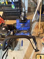 Top view of Snow Joe snow blower showing handle assembly and wheels