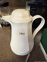 Full view of white Thermos carafe with lid, handle and spout