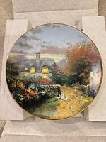 Front view of porcelain plate showing artwork and gold rim