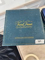 Closed dark teal Trivial Pursuit box top