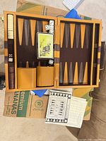 open backgammon case showing checkers, dice cups, dice, score pad, instructions