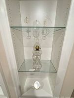 Full view of oil lamp on glass shelf inside cabinet