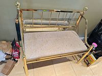 Front view of brass bench showing frame, seat cushion and backrest