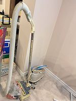 Full view of canister vacuum with hose, wand, power head and attachments visible