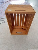 Crate front showing slatted sides, bottom cutout handle