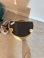 Top view of the yellow/cream plastic step stool showing black tread surface and tape residue