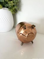 front view copper piggy bank showing face and legs