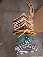 Overview of assorted hangers laid on floor next to box