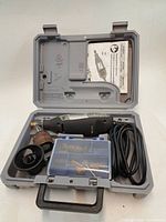 Kit open showing Dremel tool, cord, accessory box, loose attachments