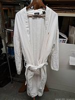 Full view of white bath robe on hanger showing overall design, belt and pockets