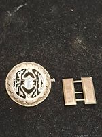 Round scarab brooch and rectangular brooch front view
