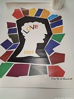Full view of the Yves Saint Laurent 1985 Love poster showing design elements, printed signature and visible creases