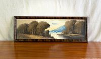 Full view of framed panoramic painting on tabletop