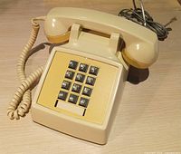 Full view of beige Northern Telecom 2500 desk telephone with handset and cords