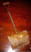Full view of rusted steel blade and wooden shaft
