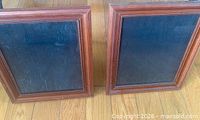 Front view of both wood frames showing brown finish and beaded inner border