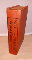 Spine and boards of orange cloth hardcover book Not as a Stranger