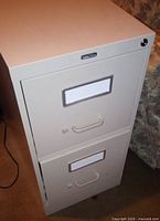 Front view showing two drawers, handles, label slots, lock