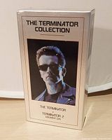 Front view of silver slipcase showing title and Arnold Schwarzenegger image
