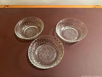 Three clear glass bowls top view showing floral rose pattern and scalloped sides