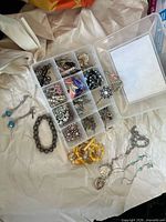 Overview of lot showing organizer with jewelry, bracelet, earrings, bead bag and heart pendant necklace