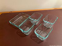 angled view showing all five Pyrex glass dishes nested, highlighting clear glass and blue tint