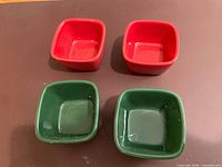 Top view of four square ceramic ramekins, two red two green