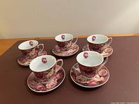 Five teacups on saucers showing complete set