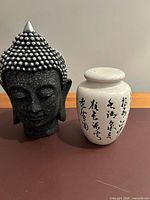 Buddha head bust and ginger jar side by side