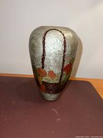 Front view of painted brass vase with fruit basket motif