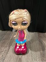 Full view of doll standing on magenta shoes