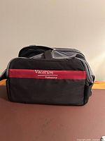 Front view showing logo, burgundy stripe, black body