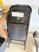 stack of six folding chairs showing fronts and frames