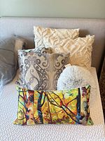 All six pillows arranged on bed showing designs and colours