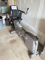 Full side view of AFG recumbent bike showing seat, pedals and flywheel housing