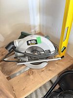 Black & Decker Quantum circular saw with cord and level beside it on shelf