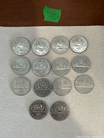 Front view of 14 Voyageur dollars arranged on paper towel