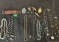 Full layout of necklaces, brooches, leather cuffs, pendant